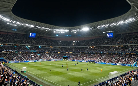 Champions-League-Stadion bei Nacht voller Fans unter Flutlicht