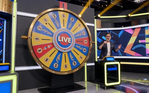 Live-Game-Show mit gro&szlig;em buntem Money Wheel und Moderator - Crazy Time