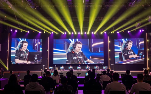 E-Sports-B&uuml;hne mit dramatischer Beleuchtung und gro&szlig;en Bildschirmen